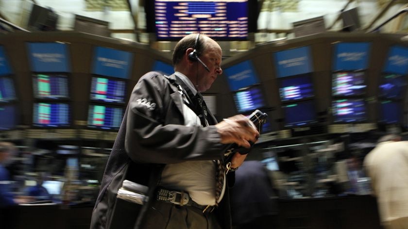 New York Stock Exchange trader stands on market floor.