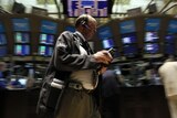 New York Stock Exchange trader stands on market floor.