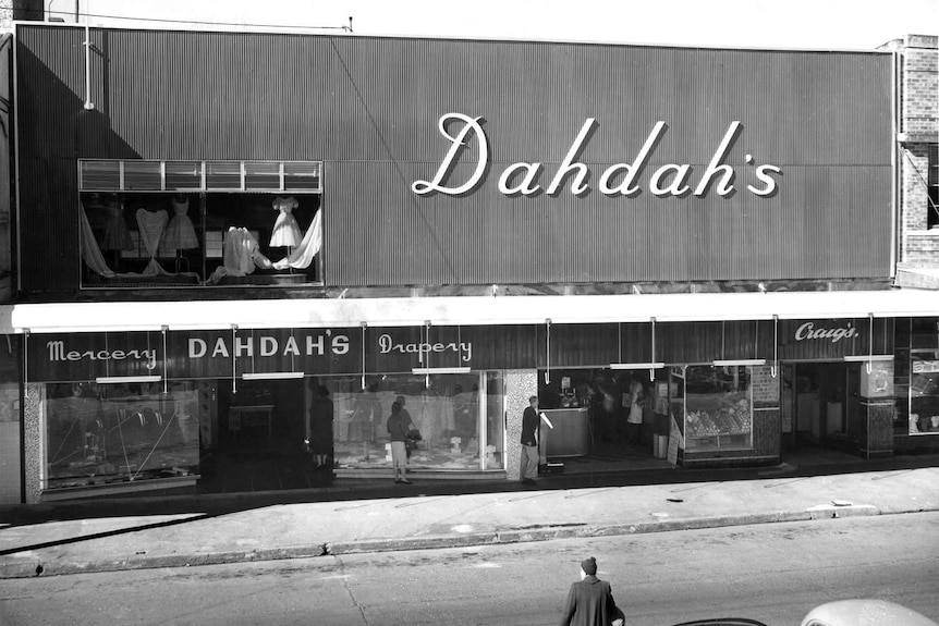 Black and white photo of a store with a large sign saying 'Dahdah's'.