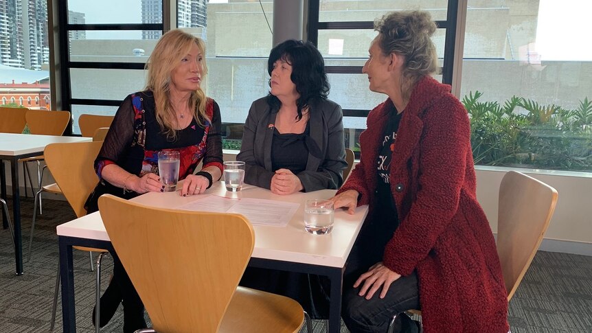 Elle Coles, Janelle Fawkes and Candi Forrest (L-R) talking at a table.