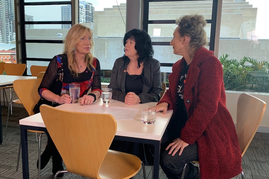 Elle Coles, Janelle Fawkes and Candi Forrest (L-R) talking at a table.