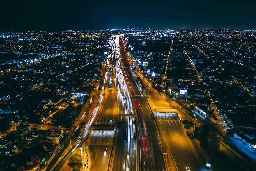 Lots of little lights flash across a busy highway in Buenos Aires, Argentina at night.