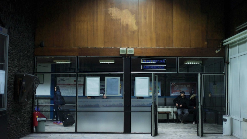 A silhouette of Yugoslavia is etched on the timber panelling above an entrance to Sarajevo train station.