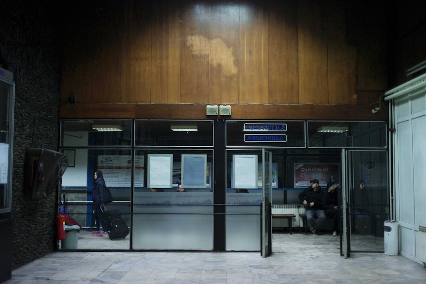 A silhouette of Yugoslavia is etched on the timber panelling above an entrance to Sarajevo train station.