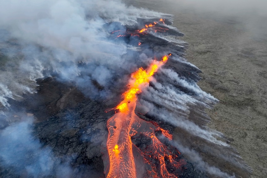 Aerial footage showing smoky mountain and fissure of lava 