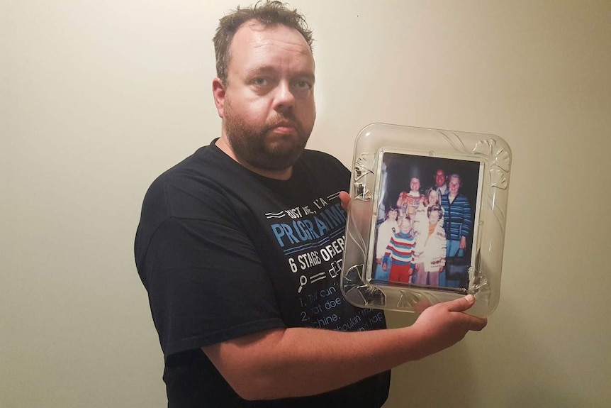 David Ward holds a photograph of his family four of whom were killed in the Granville train disaster