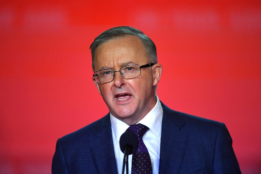 Anthony Albanese against a red background.