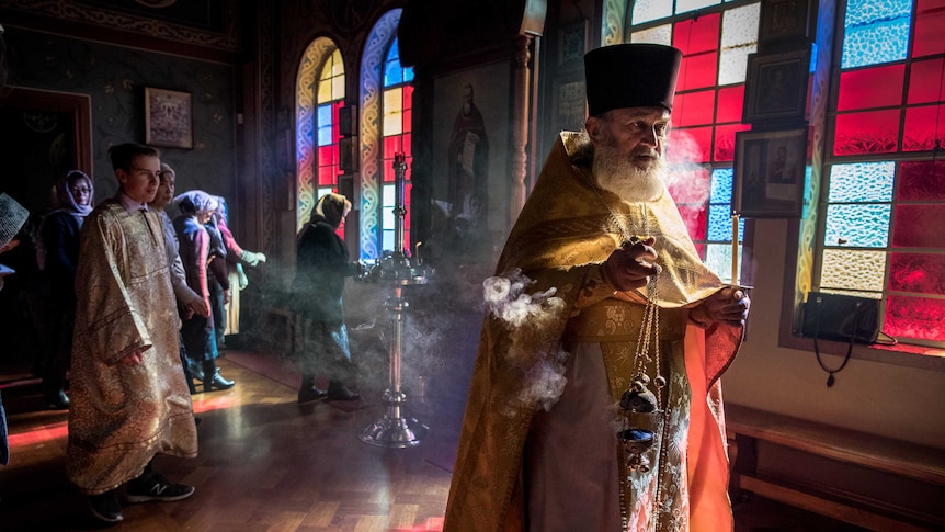 Fr. Boris Ignatievsky walks into mass with incense and wearing tradition church robes.