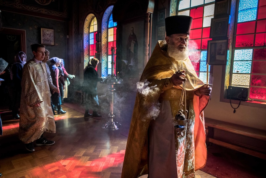 Fr. Boris Ignatievsky walks into mass with incense and wearing tradition church robes.