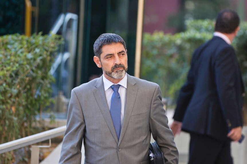 Josep Lluis Trapero, wearing a grey suit, leaves court.