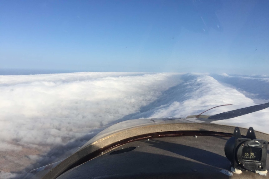 Long clouds beneath a blue sky.