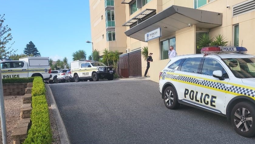 Three police vehicles parked outside a large hotel