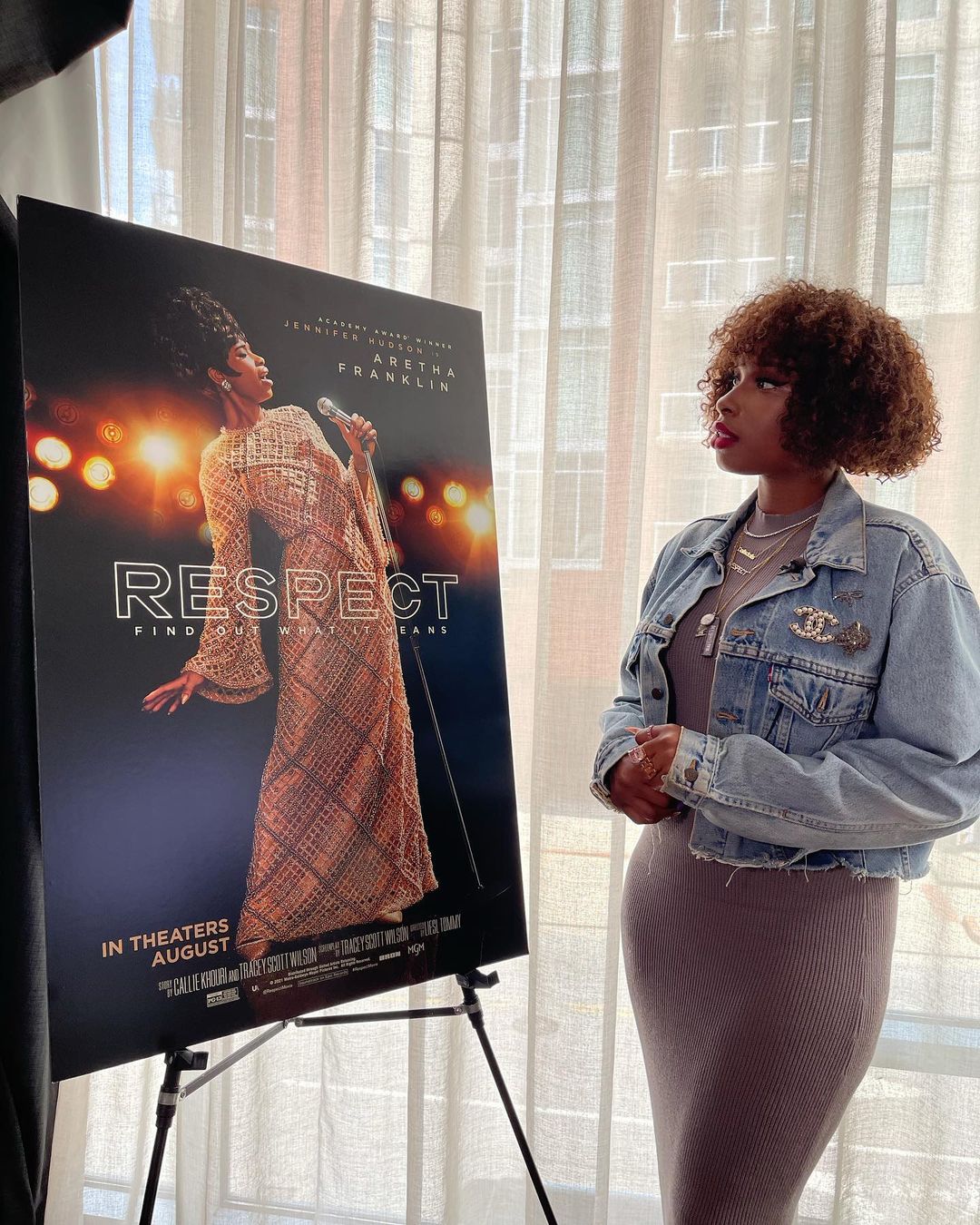 A woman looking at a poster of herself in a film.