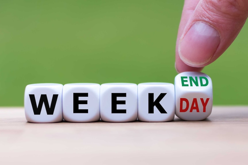 A hand turns a dice and changes the word "weekday" to "weekend".