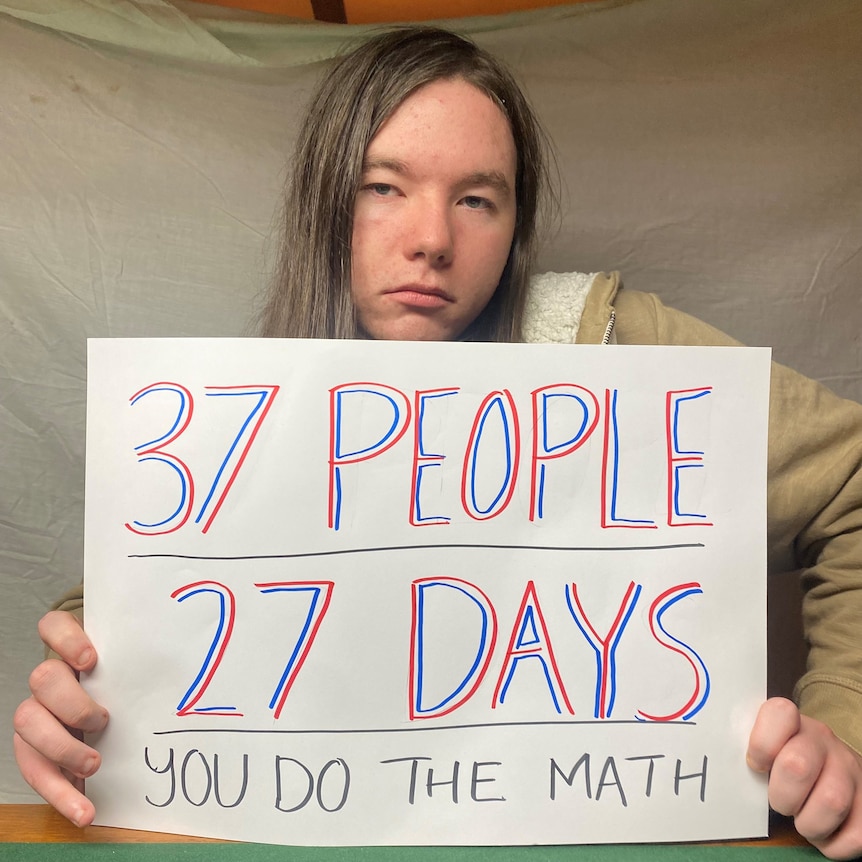 Whyalla Youth Group member Harold Flam sign reads '37 people, 27 days, you do the maths'. 