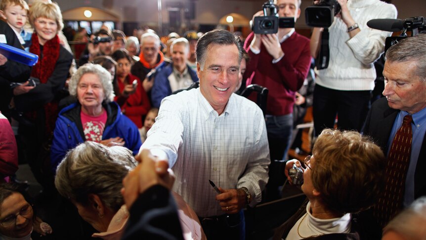 Former Massachusetts governor and Republican presidential candidate Mitt Romney greets supporters and gives autographs.