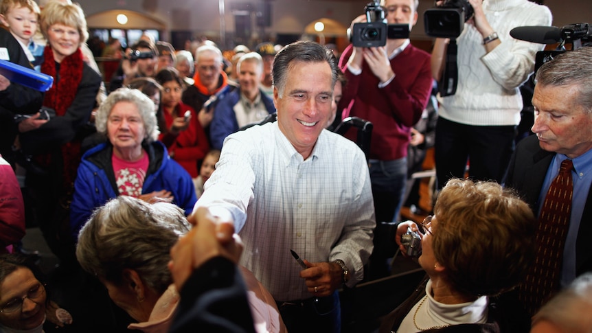 Former Massachusetts governor and Republican presidential candidate Mitt Romney greets supporters and gives autographs.