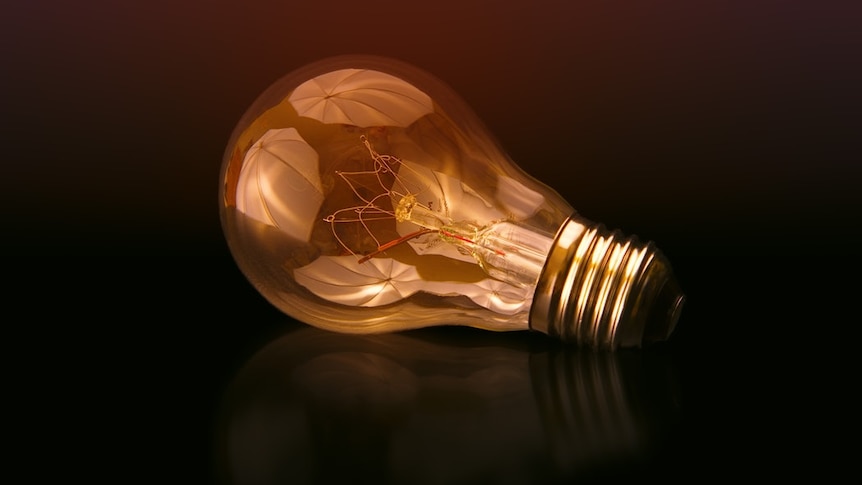 A glass light bulb on a black background