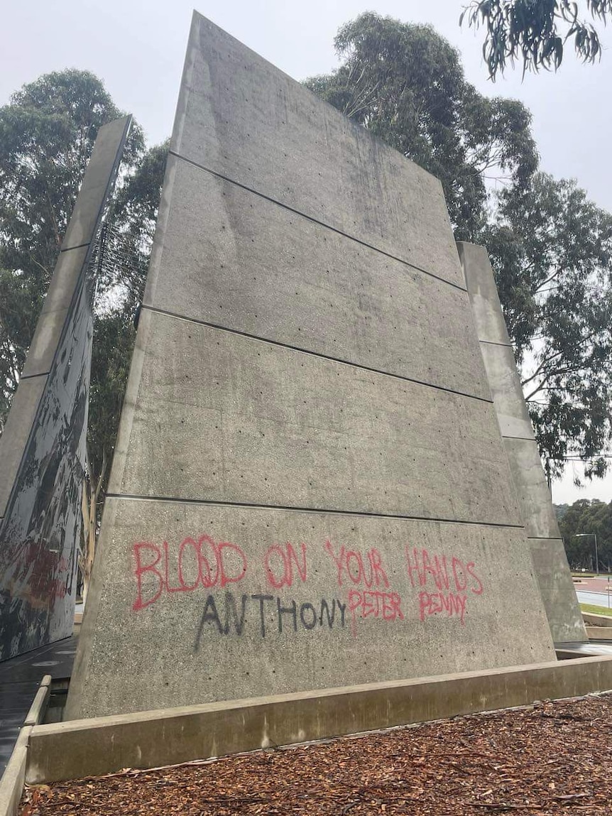 Red writing on concrete memorial. 