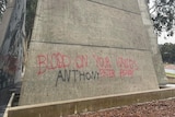 Red writing on concrete memorial. 