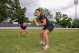 Two women wearing Australian Cricketers' Association uniforms in cricket poses