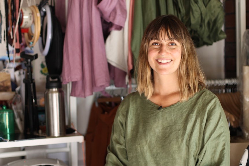 Elly Sumner sitting in front of her collection hanging in the background