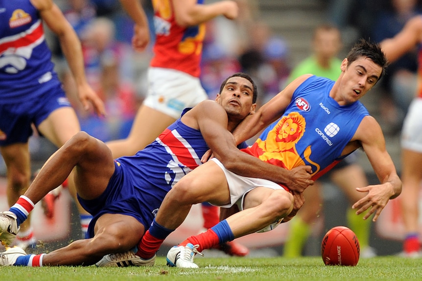 Brennan Stack of the Western Bulldogs tackles Jesse O'Brien of the Brisbane Lions