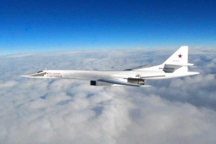 Wide shot of a Russian jet flying above clouds.