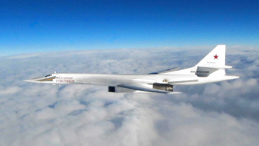 Wide shot of a Russian jet flying above clouds.