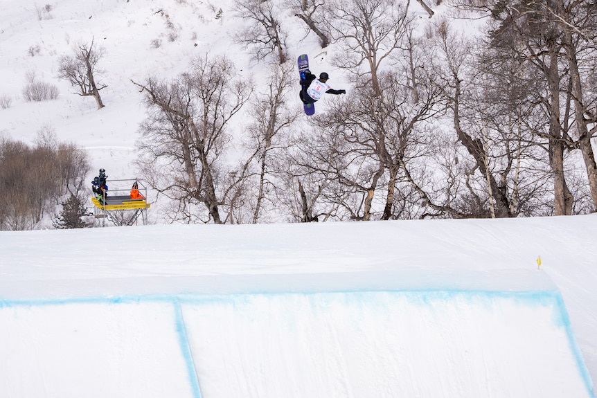 Tess Coady leaps off a jump on a snowboard.