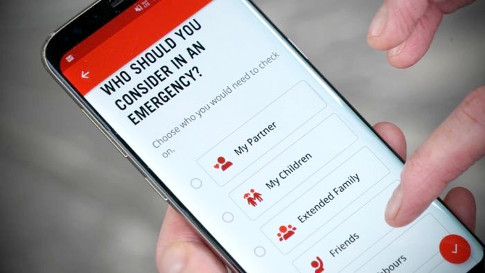 A hand holding a mobile phone, with the Red Cross Prepare app in use on the screen.