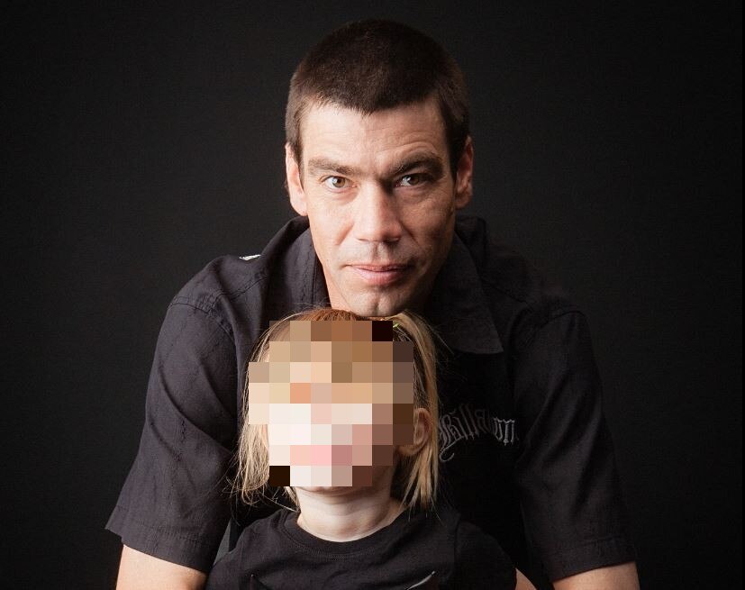 A man with short dark hair pictured with his daughter whose face is pixellated