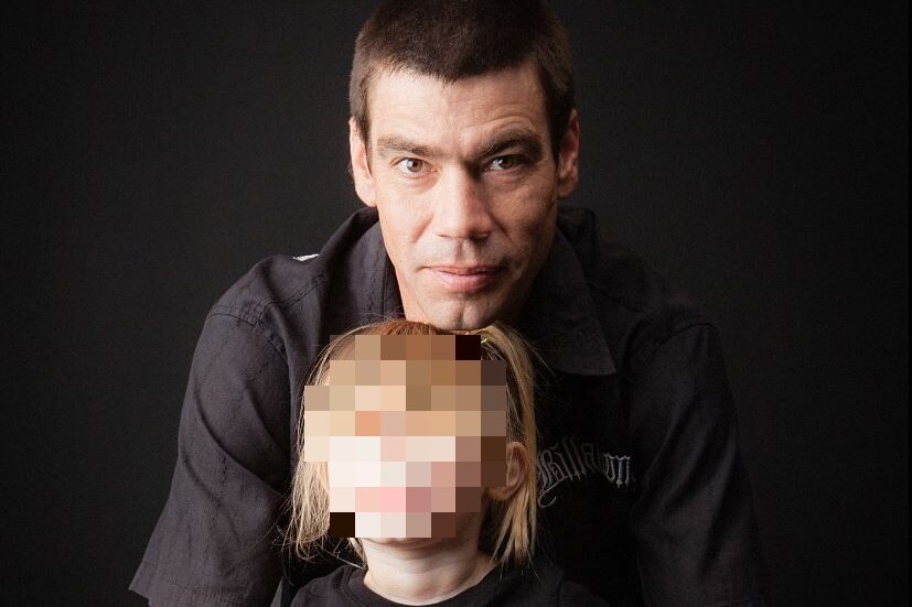 A man with short dark hair pictured with his daughter whose face is pixellated