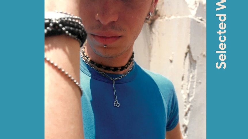 A book cover with a blue border showing a photograph of a young man wearing a blue t-shirt, with one hand shielding his eyes