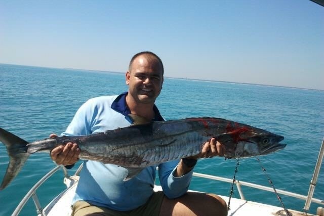 Thomas MacIntyre poses with a fish on a boat