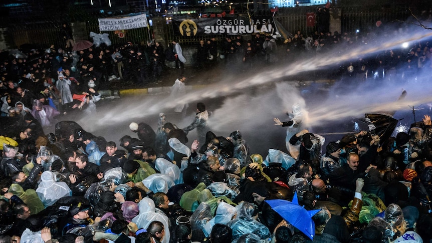 Turkish riot police use water cannon and tear gas to disperse supporters at Zaman daily newspaper headquarters in Istanbul