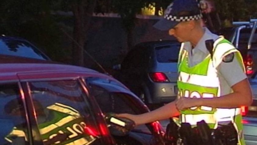 A police officer taking an RBT sample from a motorist