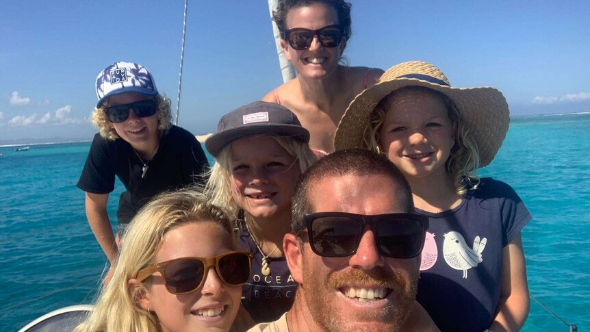 The Fothergill family pose for a photo aboard their yacht.
