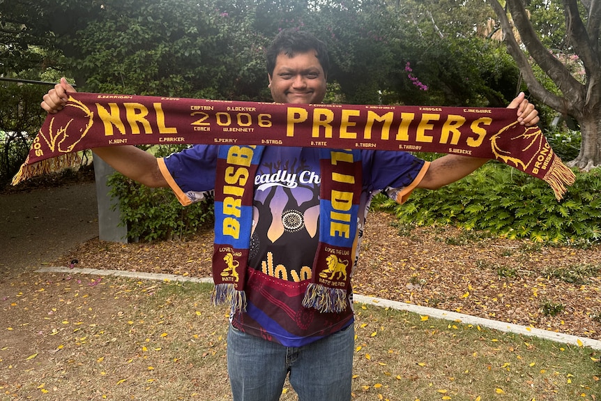 Man holds up Broncos scarf