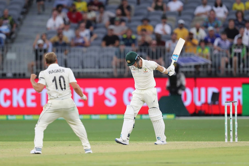 Steve Smith flicks his bat in frustration as Neil Wagner celebrates a wicket