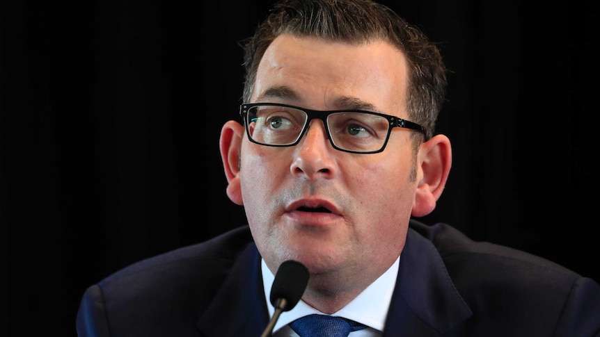 Daniel Andrews, Victorian Premier sitting in front of a microphone.