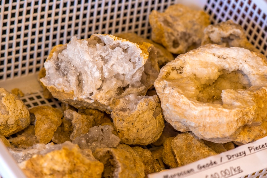 A basket of rocks cracked open to reveals the crystals.