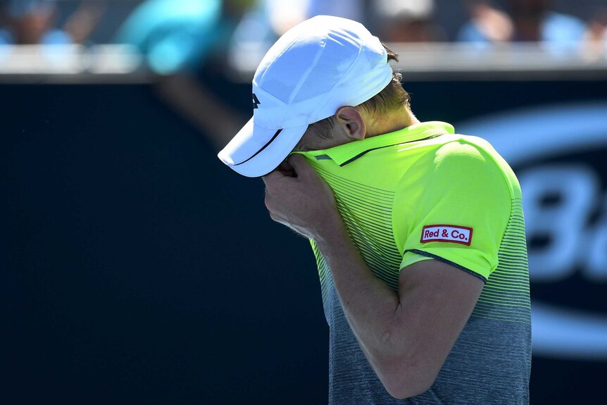 John Millman wipes his face against Damir Dzumhur at the Australian Open.
