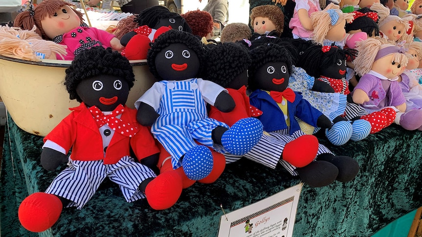 Several golliwog dolls on display at a market stall