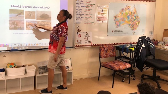 A teacher points to a projector to introduce Noongar words to a class of students