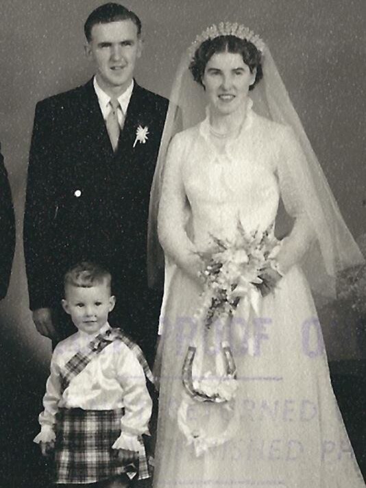 Couple in wedding photo with pageboy in kilt