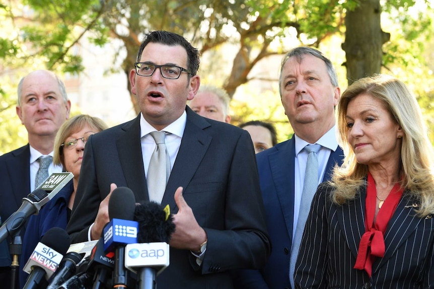 Daniel Andrews flanked by ministers and Fiona Patten speaking to the media.
