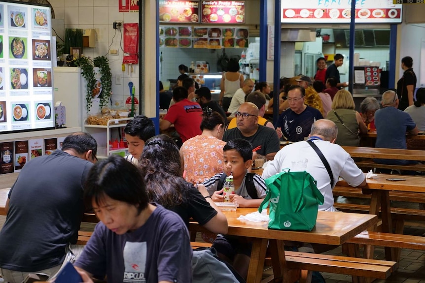 People gather and eat in a hawkers style food hall