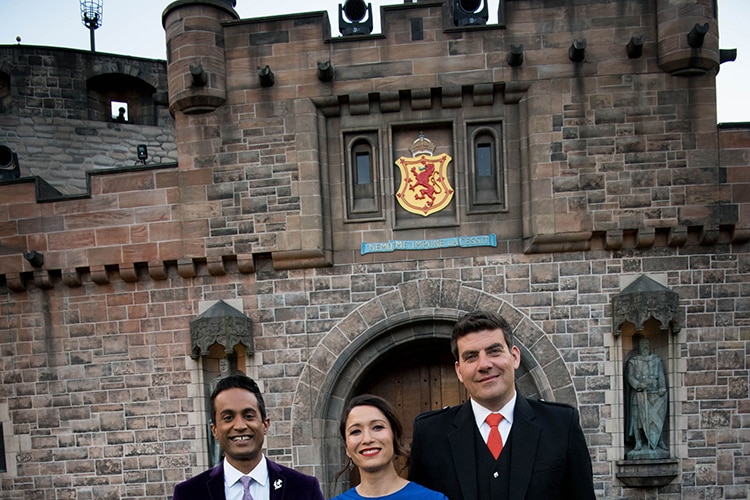 Jeremy Fernandez, Kumi Taguchi and Russell Torrance stand in front of a replica Edinburgh Castle in Sydney.
