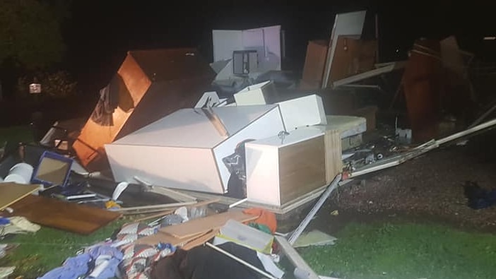 Household debris is scattered around as if the walls of the house are gone.